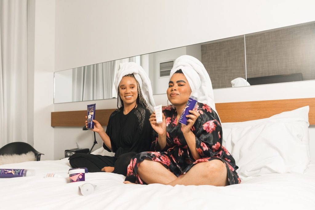 two women in bathrobe sitting on bed demonstrating the best face cream day and night