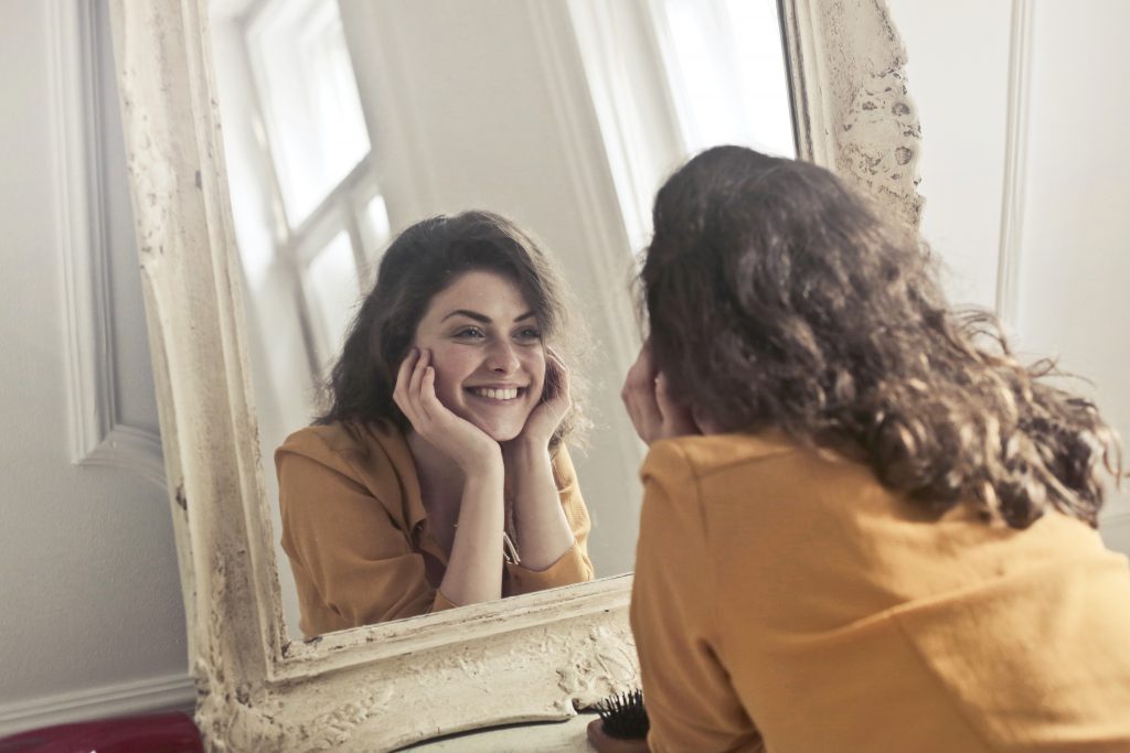 Q10 in Face Cream article - Photo of woman looking at the mirror